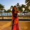 Woman in orange dress by beach sunset
