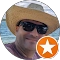 Person in hat and sunglasses by ocean