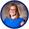 Woman with glasses smiling in blue top