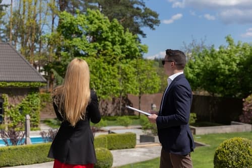Couple reviewing papers near garden home