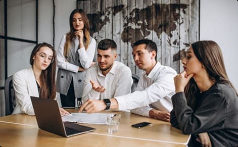 Business team collaborating around laptop
