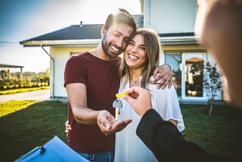 Couple receiving house key from agent
